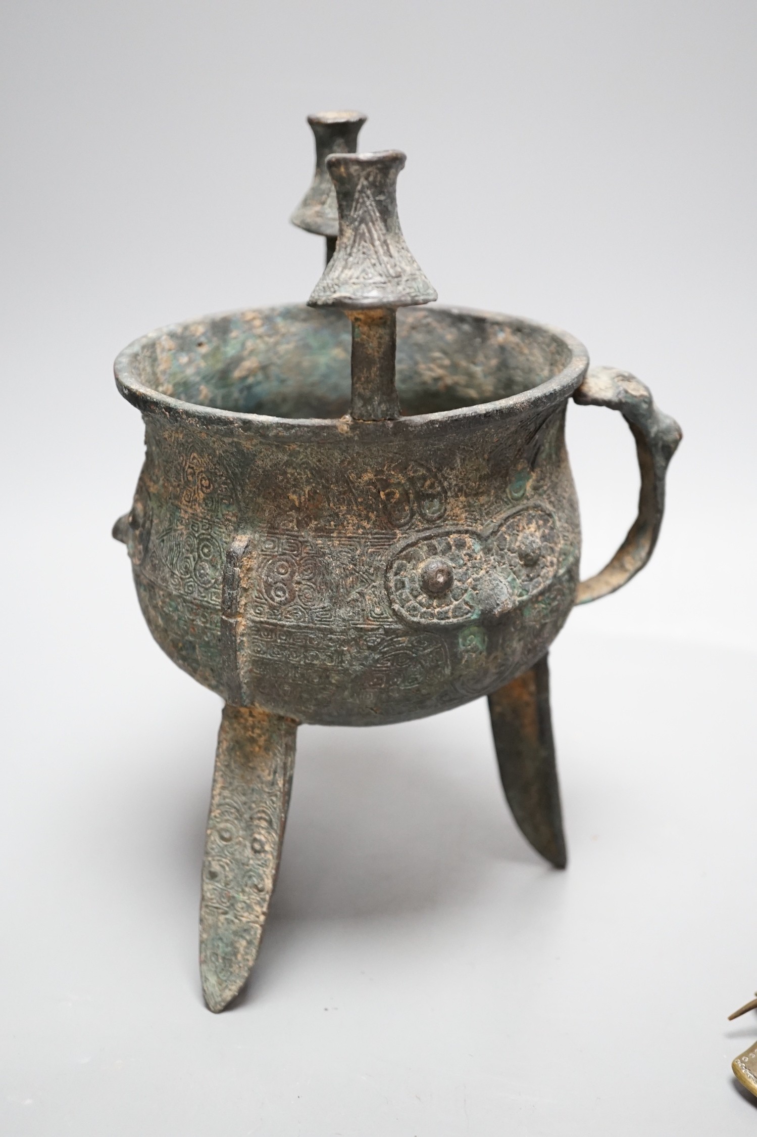 A Chinese green and russet jade belt buckle, an archaistic bronze tripod vessel and a figural bronze. Tallest 25cm